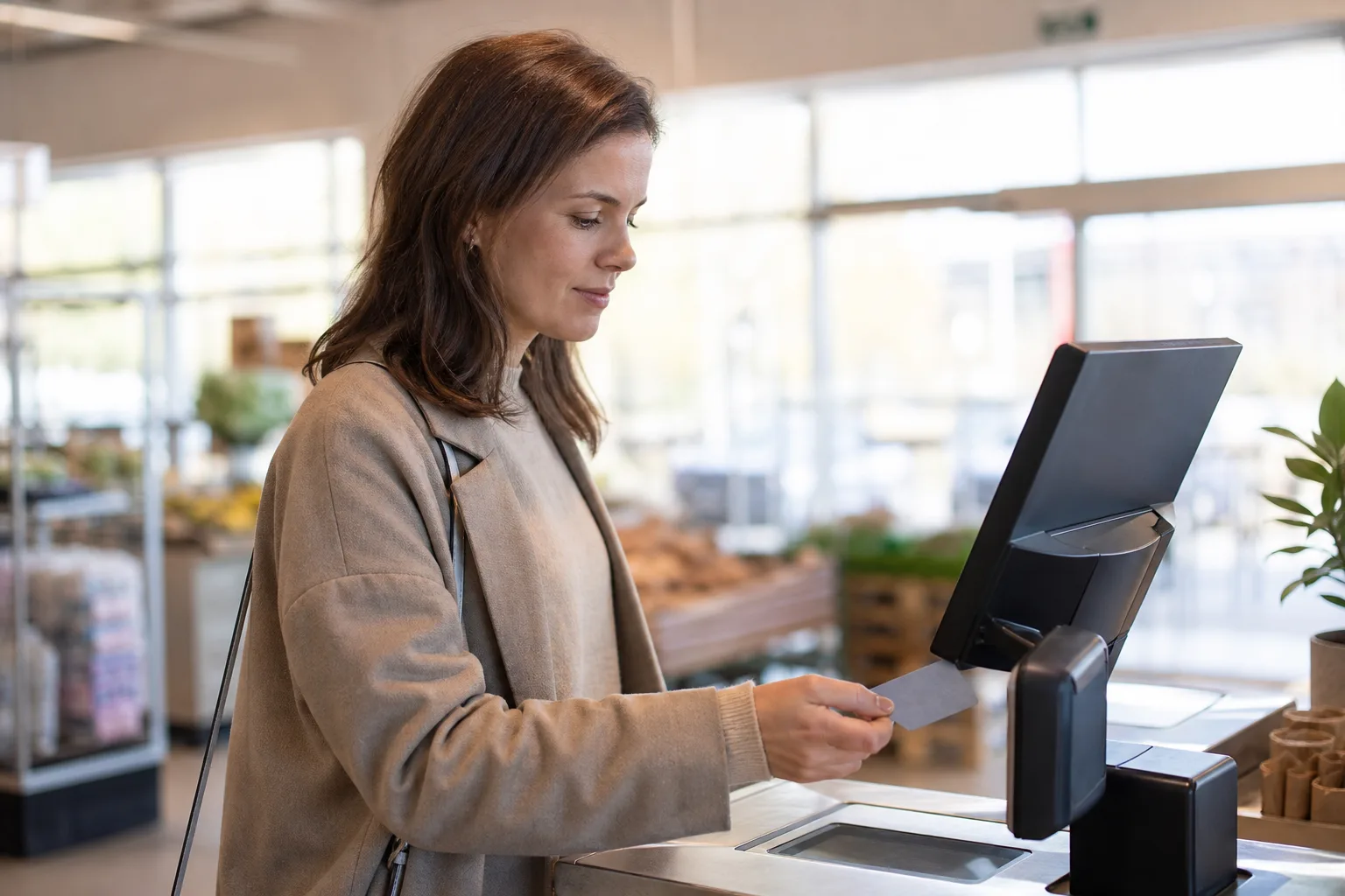 Person håller ett omärkt kort nära en neutral betalterminal.